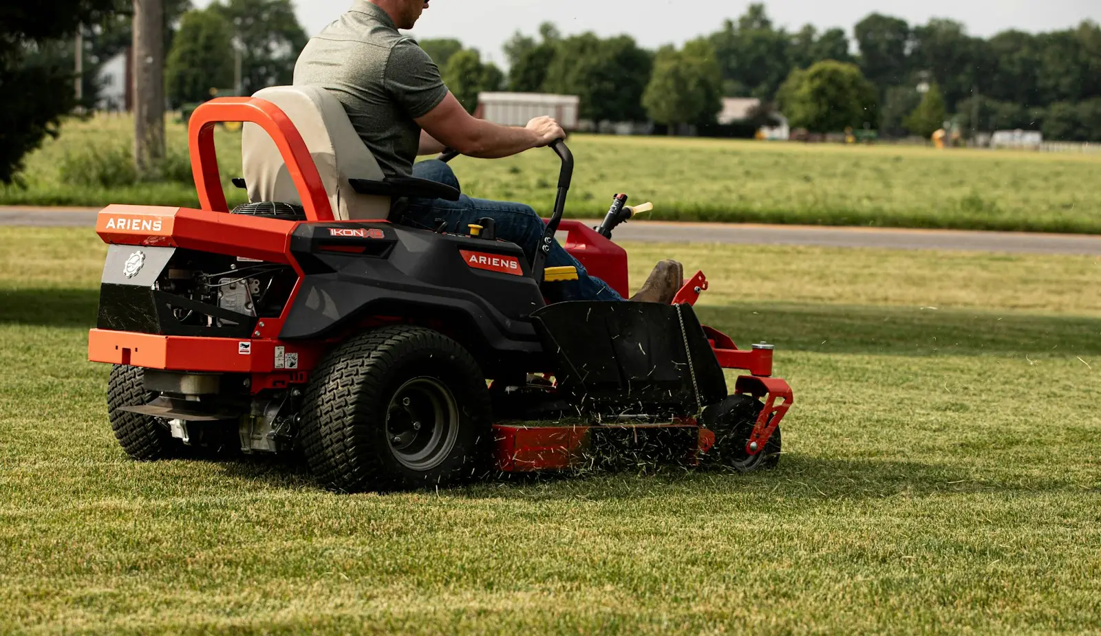 Zero turn ride-on mower crossing a green lawn